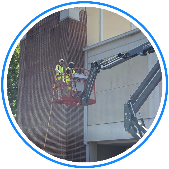 Georgia Bubbles crew soft washing a campus building from a boom lift