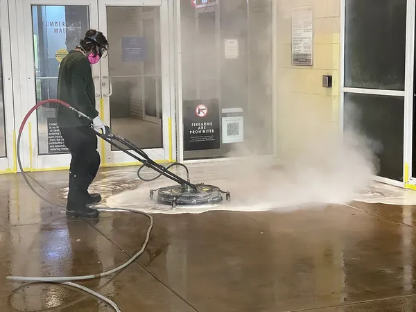 Hot-water surface cleaner steaming across a mall entrance in Atlanta overnight