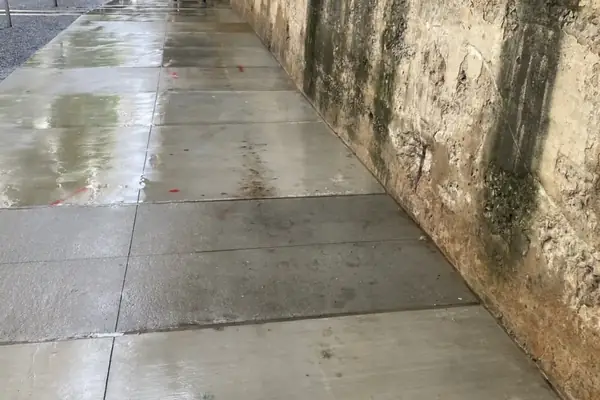 Clean concrete walkway beside the tall wall in a covered pedestrian passage in downtown Atlanta, after washing