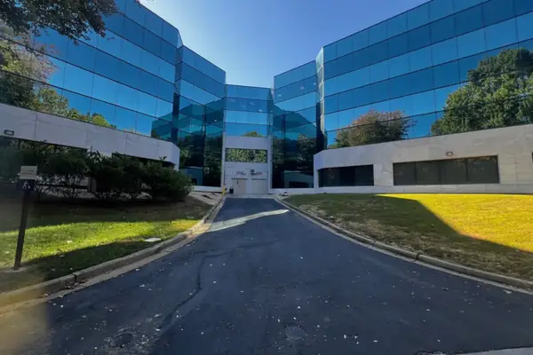 Office building in Smyrna, GA after its building wash, with glass wings and clean stone panels around the courtyard